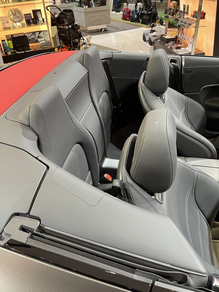 지붕을 연 메르세데스-AMG SL 43의 앞좌석 뒤로 보이는 작은 뒷좌석 두 개와 좁은 다리 공간