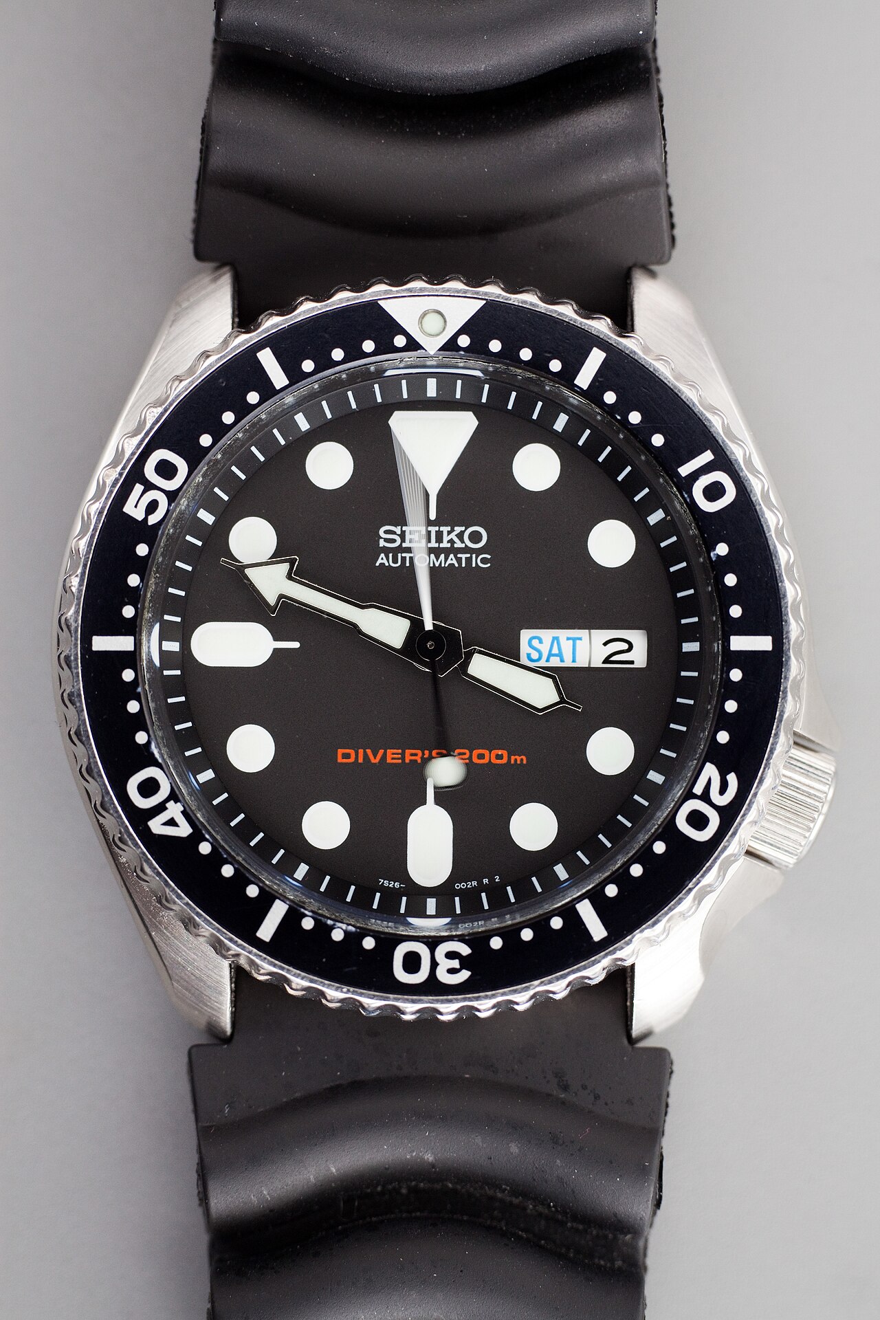 검은 고무 스트랩을 단 세이코 SKX007의 다이얼 확대 사진. 흰색 눈금과 시침·분침, 움직임이 겹쳐 보이는 가느다란 초침이 보인다.