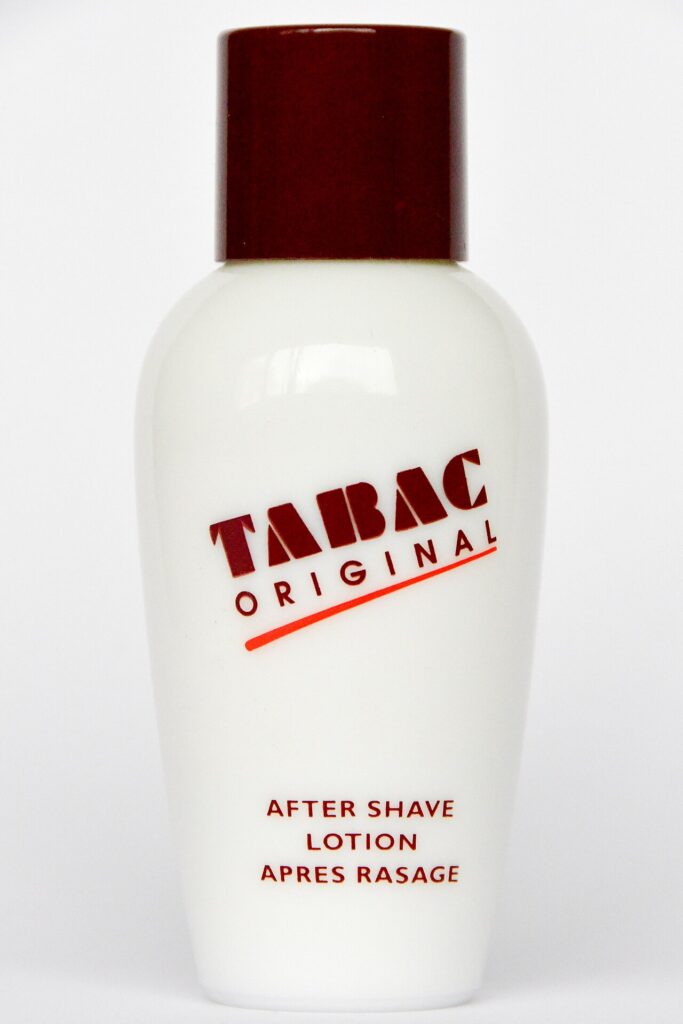짙은 갈색 뚜껑과 ‘AFTER SHAVE LOTION’ 표시가 있는 흰색 타박 오리지널 용기