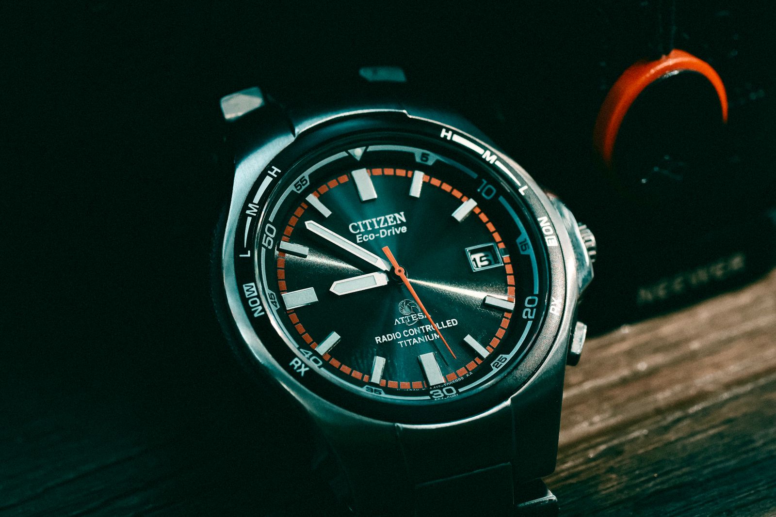 Eco-Drive 표기와 주황색 초침이 보이는 시티즌 손목시계 다이얼